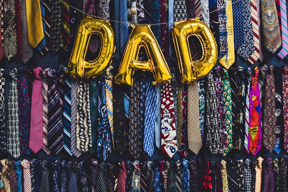 Gold balloon letters spelling 'DAD' with colorful neckties for Father's Day celebration.